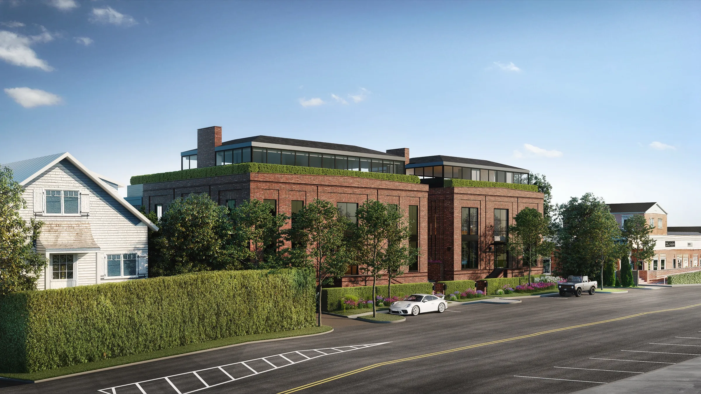 Exterior 3D rendering of an earlier scheme for 2 West Water Street seen along the street in Sag Harbor, brick buildings with hipped glass rooftop levels behind a tall hedge, beside a shingled house next door.