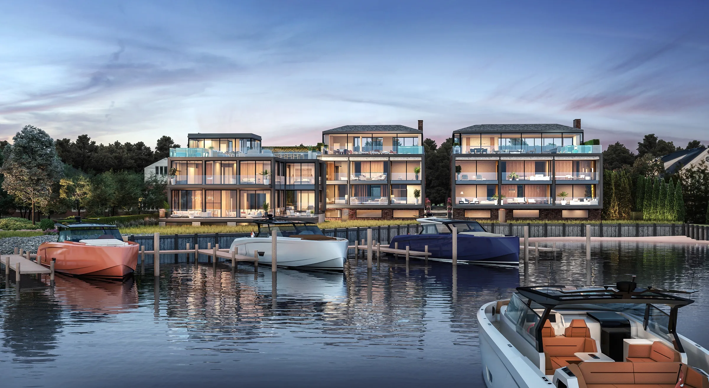 Dusk 3D rendering of the three residences at 2 West Water Street seen from Sag Harbor Cove, their glass rear facades lit from inside above the bulkhead, with three boats moored at a timber dock and a launch in the foreground.