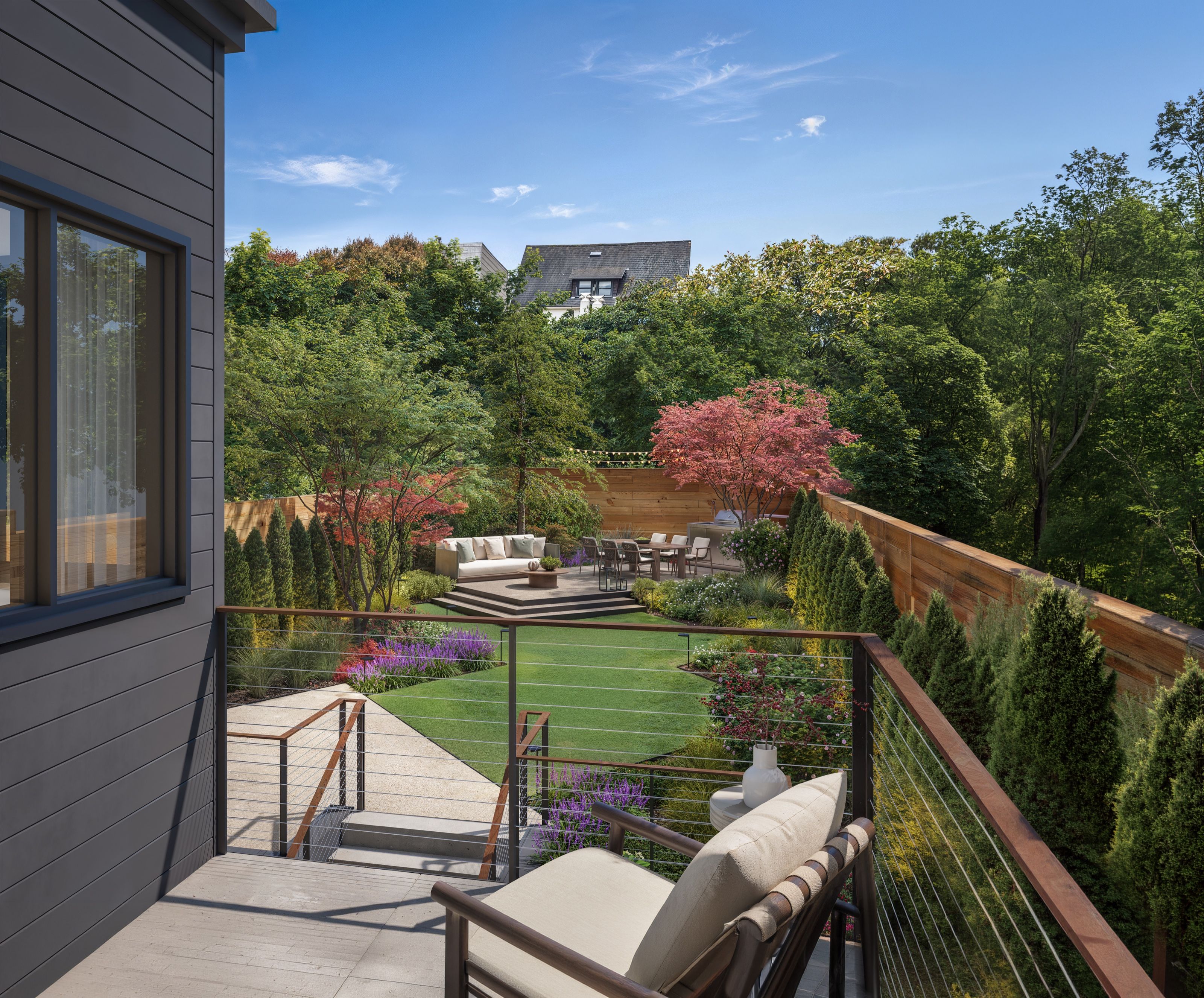 A photorealistic 3D architectural rendering by NoTriangle Studio looking out from the rear deck of 3740 Sacramento Street in San Francisco over the landscaped backyard, with a cable-rail balustrade in the foreground, a lawn, Japanese maples, and a lounge and dining area beyond.