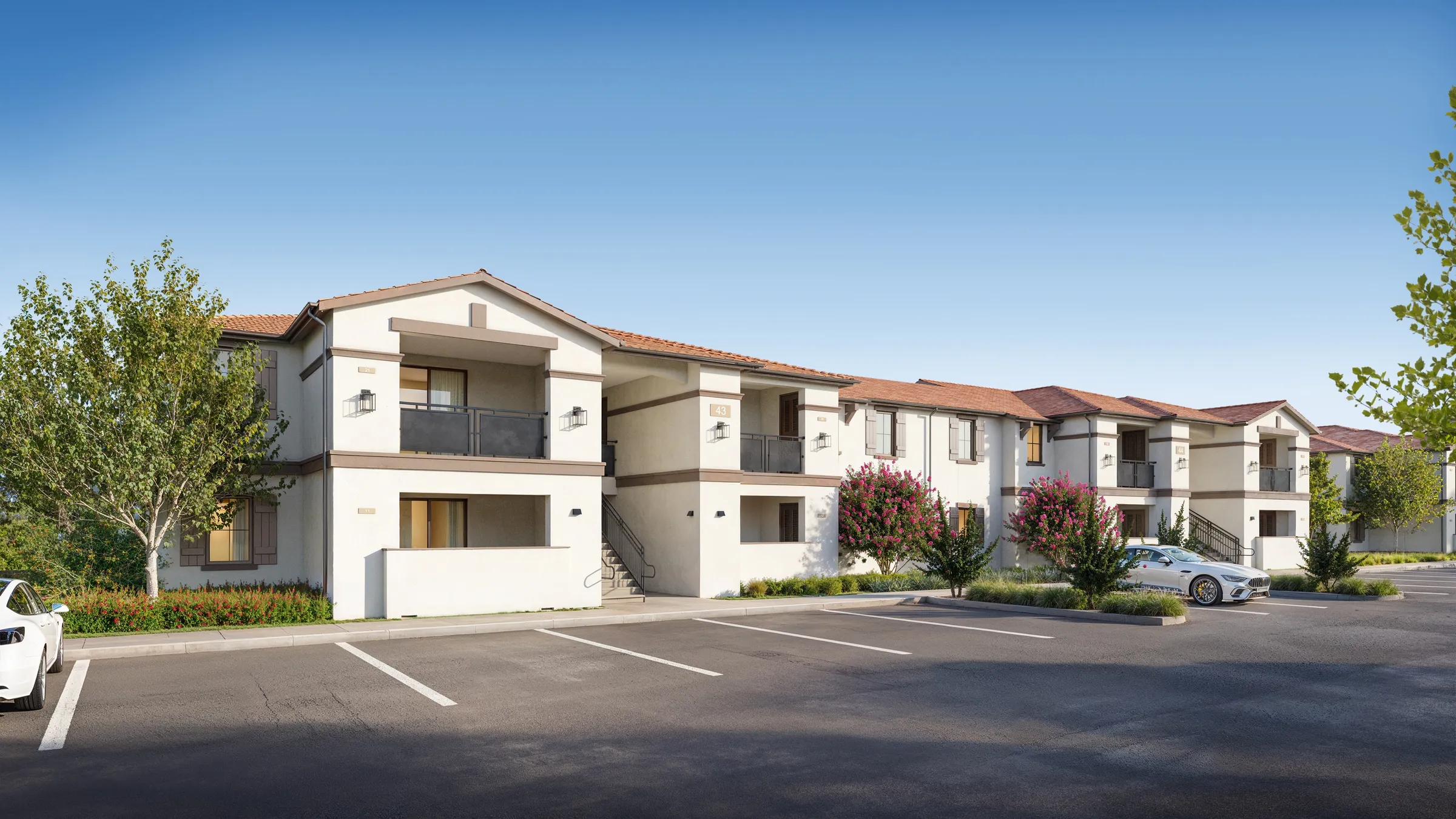 Two-story garden-style apartment building at Gateway Commons with white stucco walls, a red clay-tile roof, private balconies, and a parking court in front, a photorealistic 3D rendering.