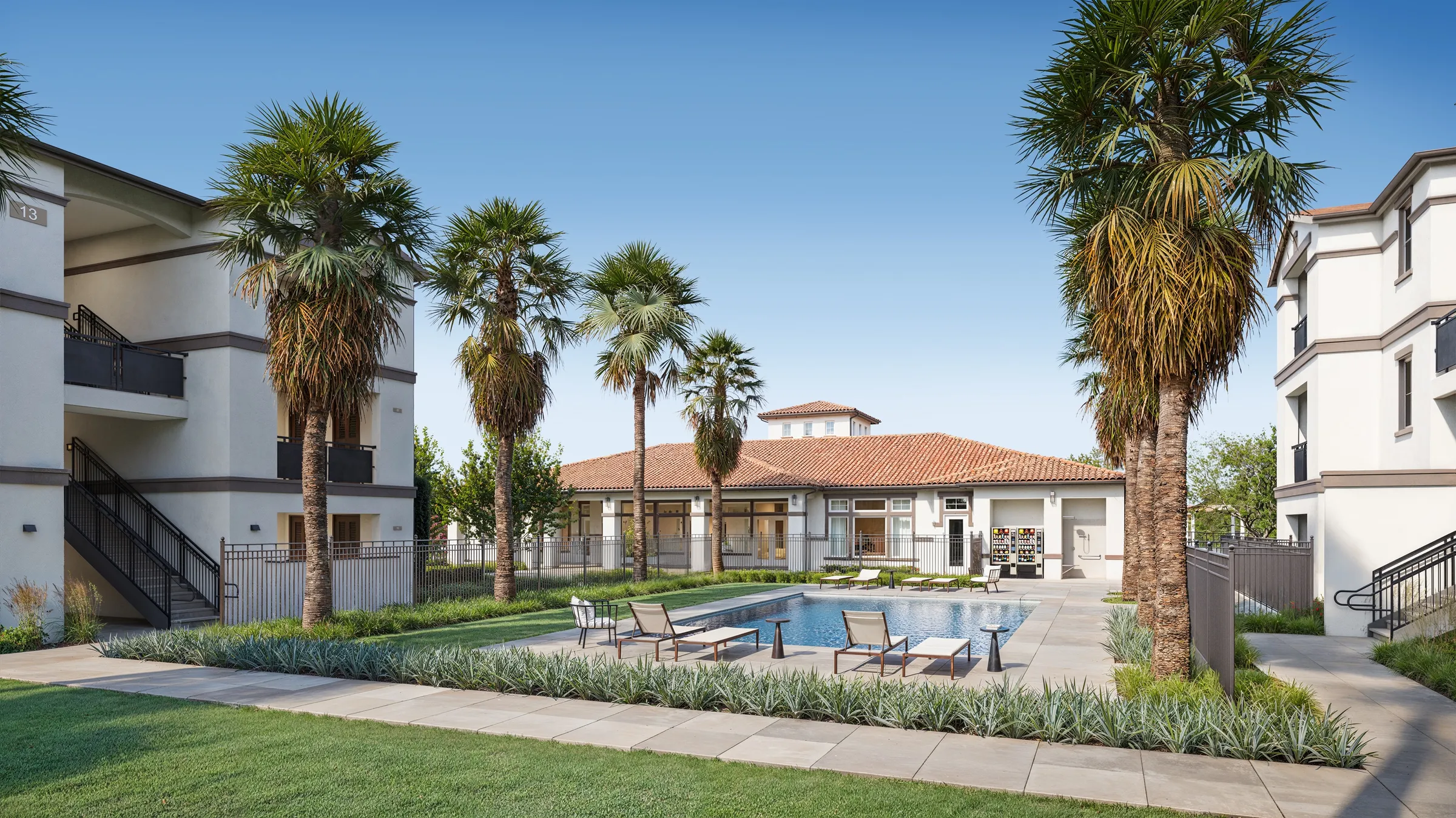 Resort-style pool courtyard at Gateway Commons, a garden-style apartment community by Ginder Development in California's Central Valley, lined with palm trees and sun loungers with the tile-roofed clubhouse behind, a photorealistic 3D rendering.