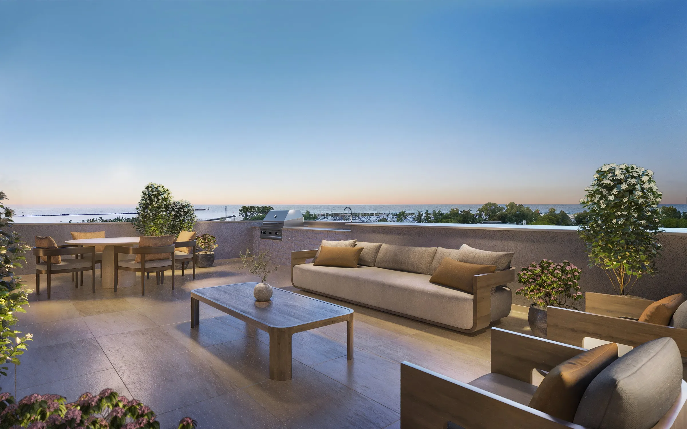 Twilight 3D rendering of a townhome rooftop deck lounge at SoLa in Michigan City, Indiana, with a long outdoor sofa, a coffee table, a dining set, a built-in grill, and an open view to Lake Michigan.