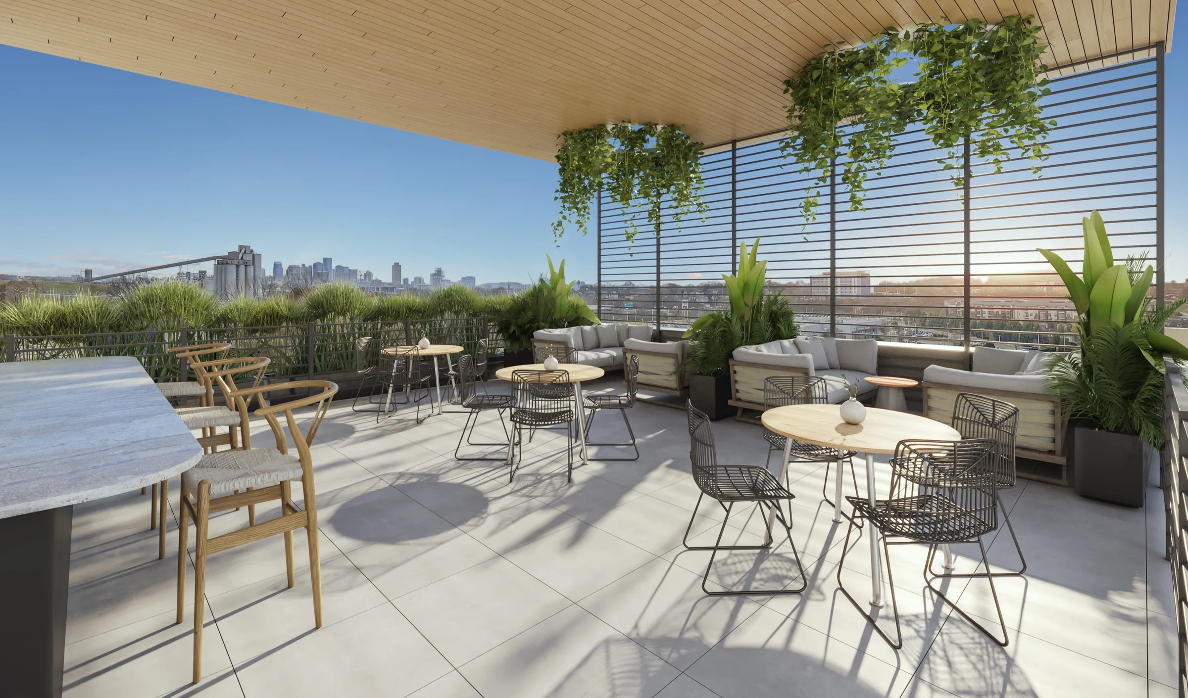 3D rendering of The Ivy’s rooftop amenity terrace under a timber pergola, set with cafe tables and banquette seating, looking out over the Nashville skyline with a bridge on the horizon.