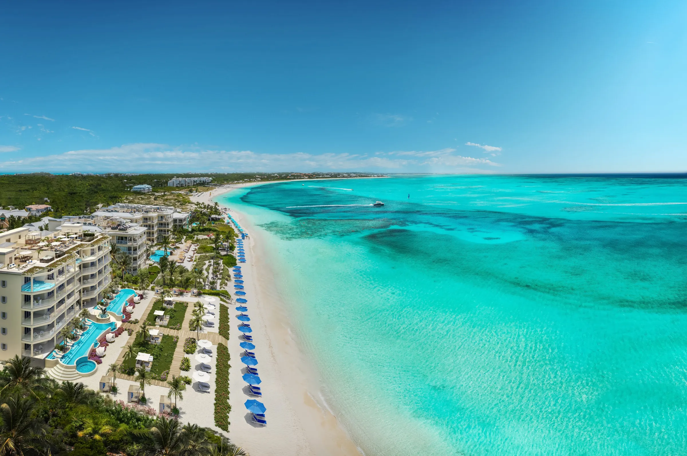 Aerial 3D rendering of the beachfront resort in Turks and Caicos seen from over the sea, its pools and terraces along a white-sand beach that gives way to the banded turquoise water of the reef.