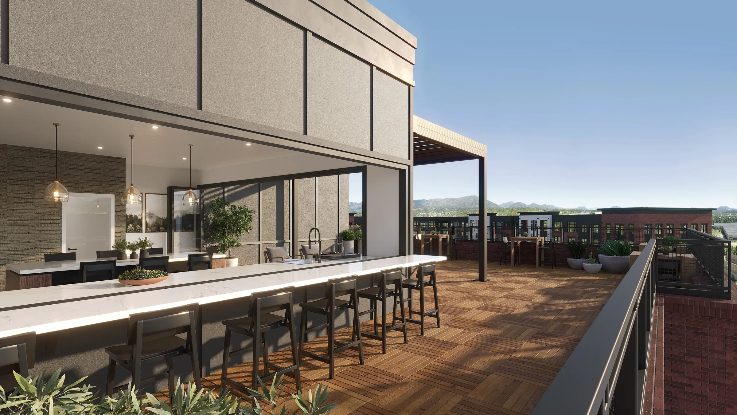 3D rendering of the rooftop lounge at Valleydale Apartments in Salem, Virginia, a long white-topped bar with black stools opening from an indoor kitchen onto a wood-decked terrace with a pergola, looking over the brick buildings to distant mountains.