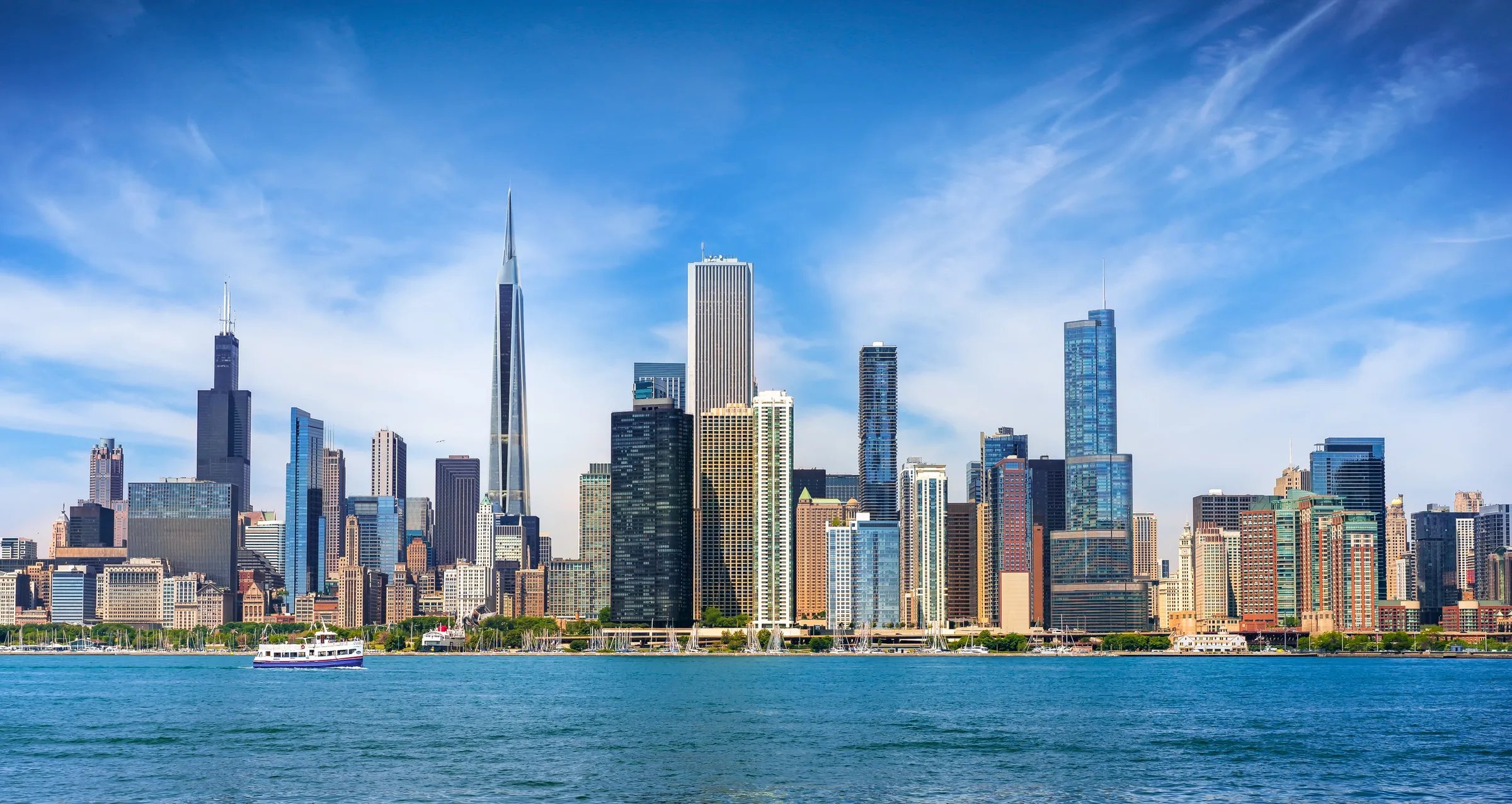Daytime 3D rendering of a proposed residential tower on West Madison Street in Chicago, a slender glass spire shown within the Chicago skyline as seen across the water from Lake Michigan.