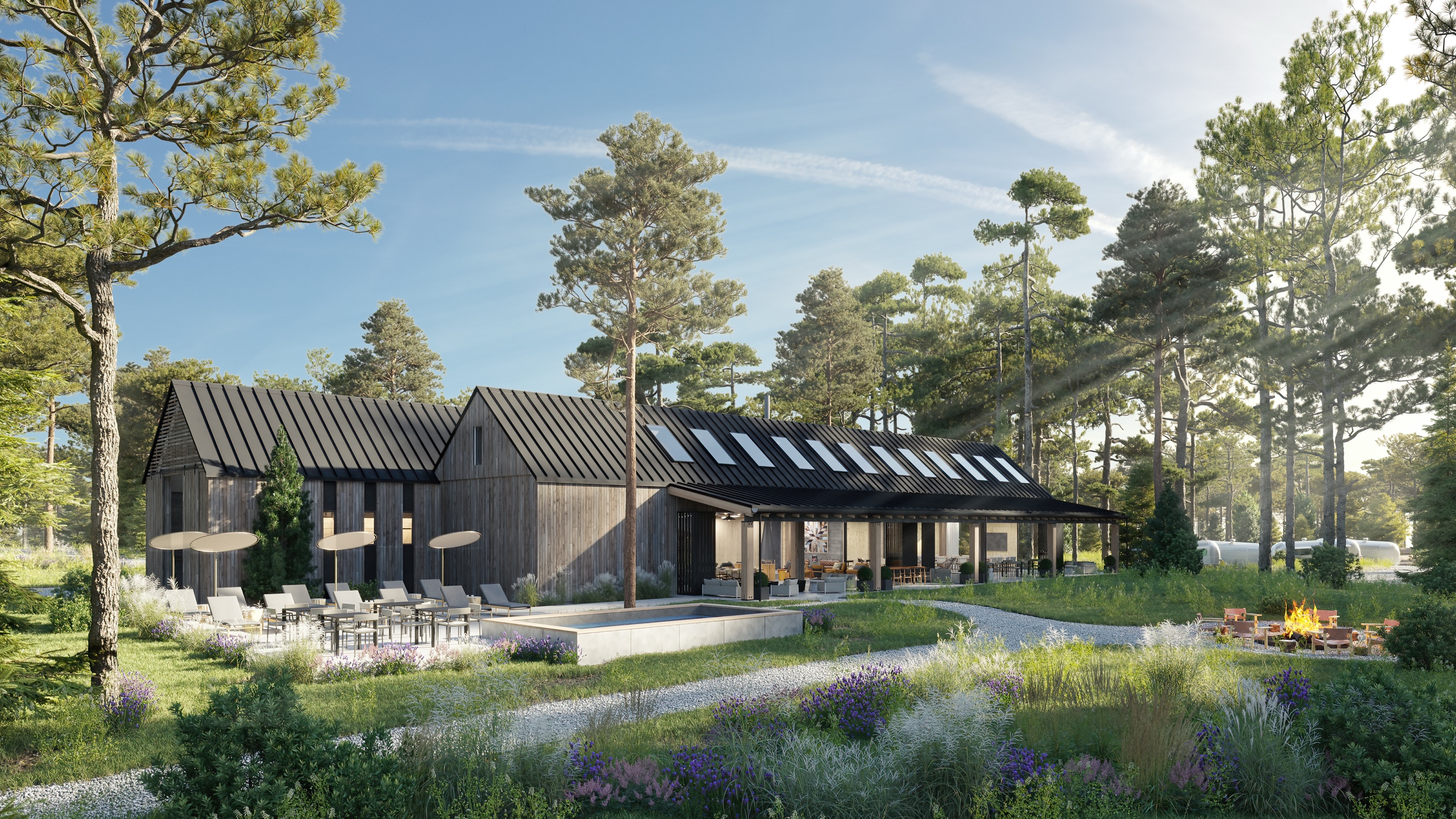 Daytime 3D rendering of the AutoCamp Catskills clubhouse and pool, with lounge chairs and umbrellas on the deck, a firepit, and the gabled cedar building behind, set in a meadow among pines.