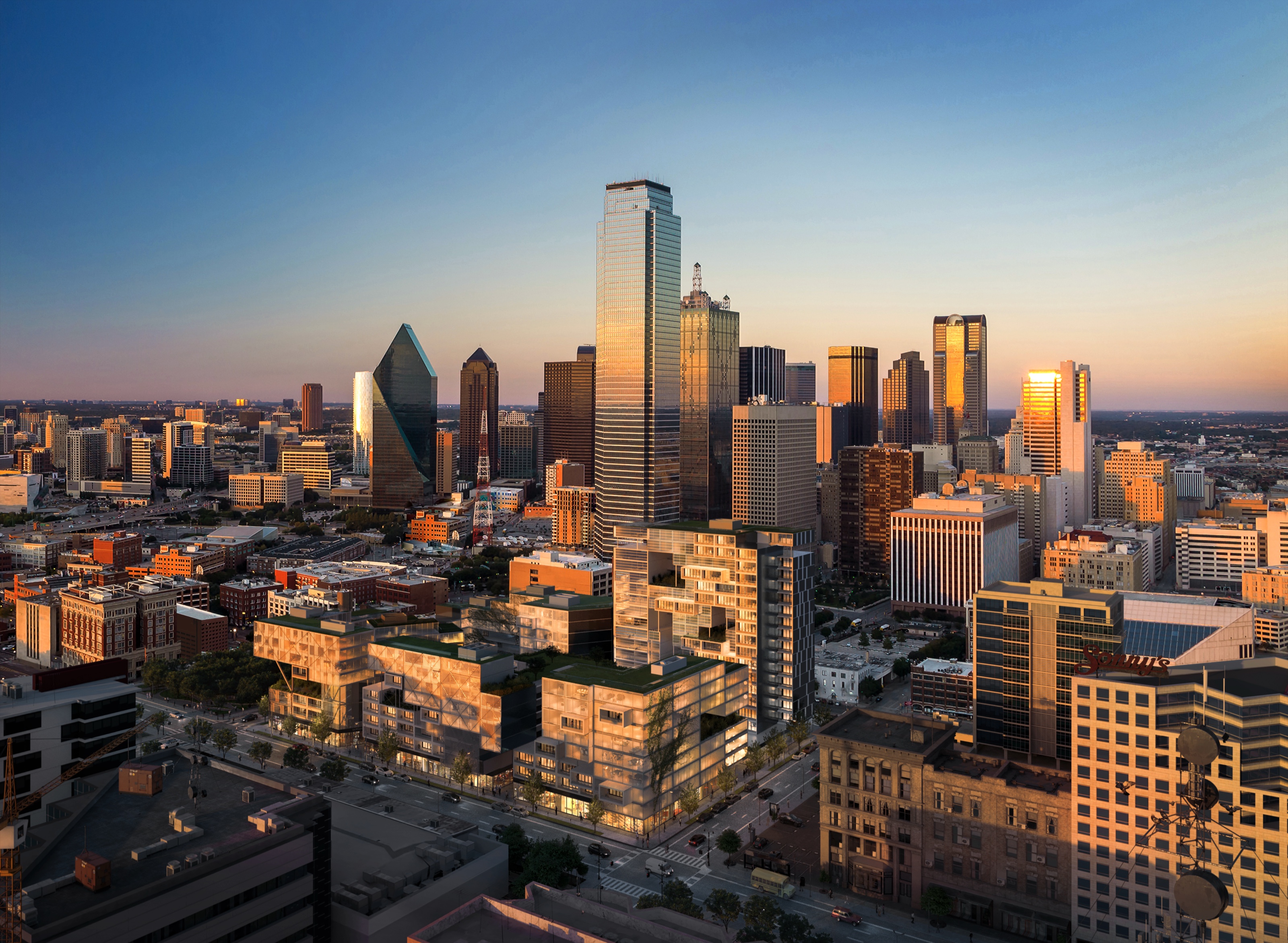 Dusk aerial 3D rendering of the Re-Vision Dallas concept, a low-rise block of glass volumes with green roofs and a slender residential tower, set against the real downtown Dallas skyline.