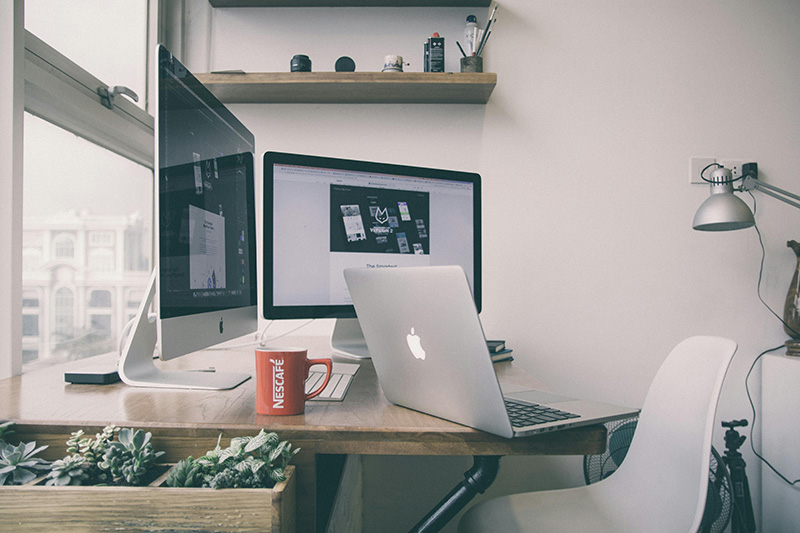 desk with many computer screen